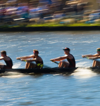 men's team sculling on a river